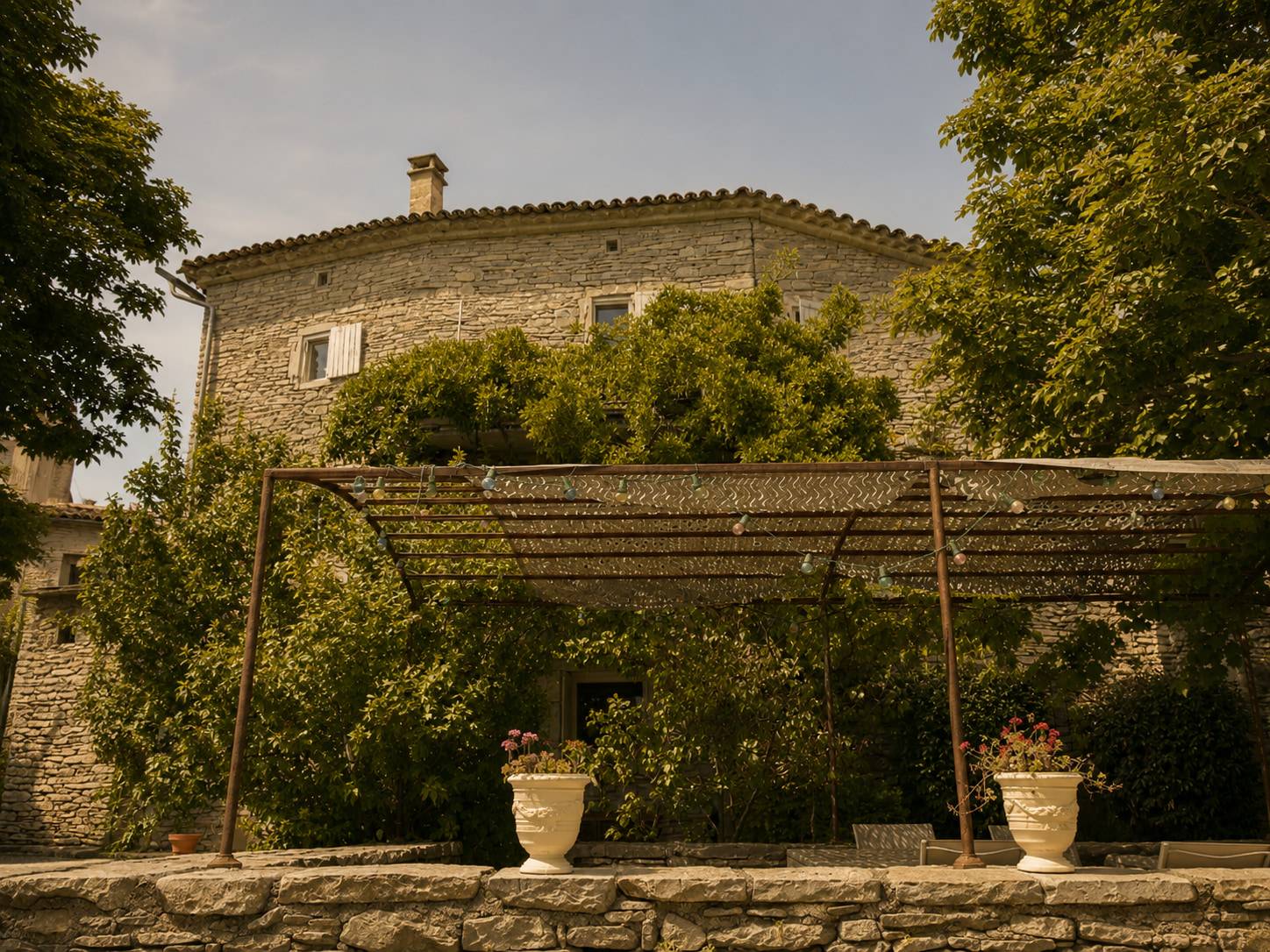 Bâtisse en pierre du Hameau des Sources, sa treille et ses jardins.