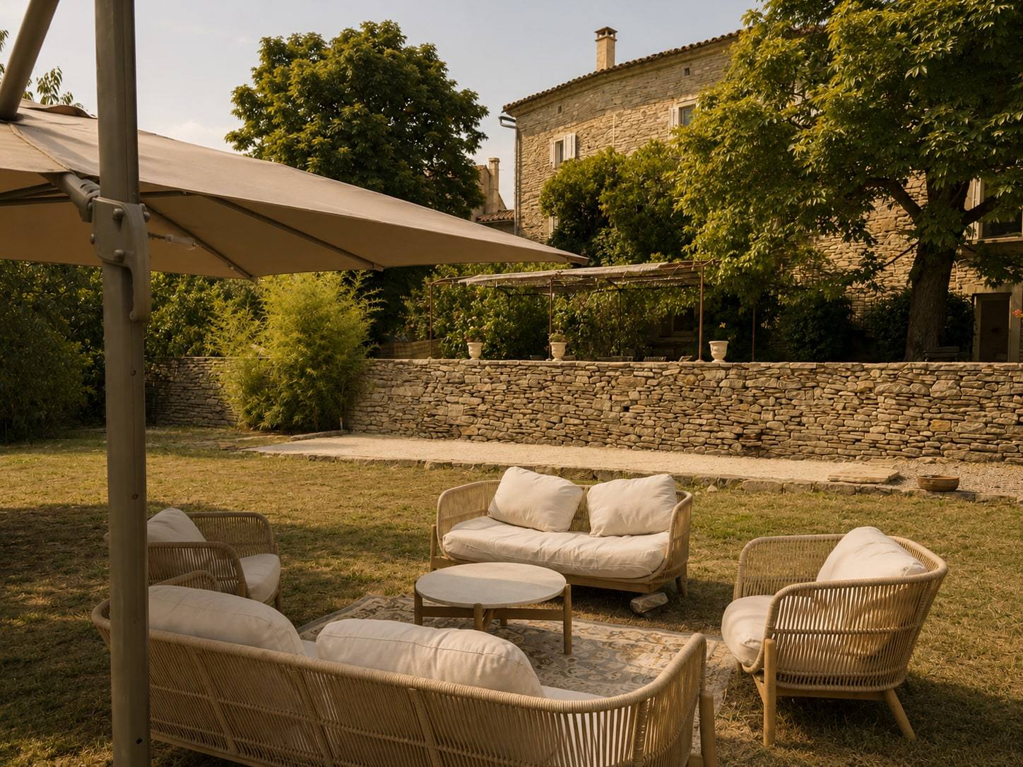 Salon de jardin sur la pelouse, à l’ombre d’un parasol.
