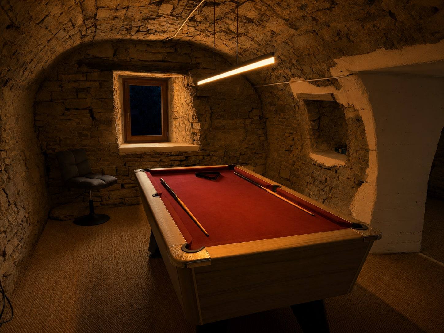 Billard installé dans une salle voûtée en pierre.