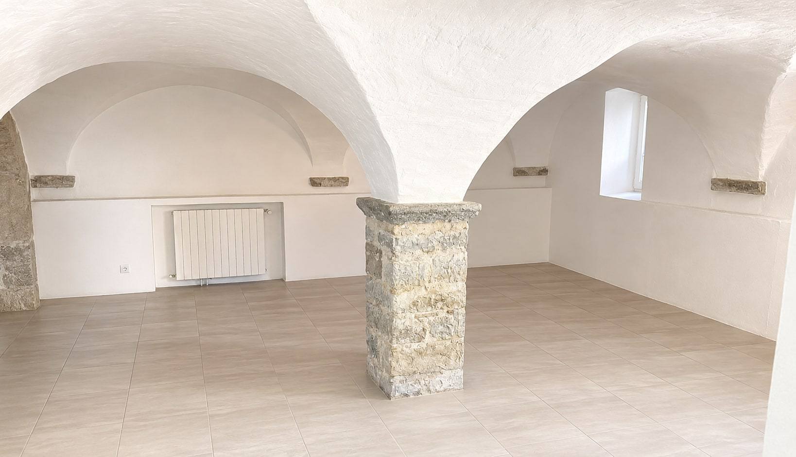 Salle voûtée et sa colonne en pierre.