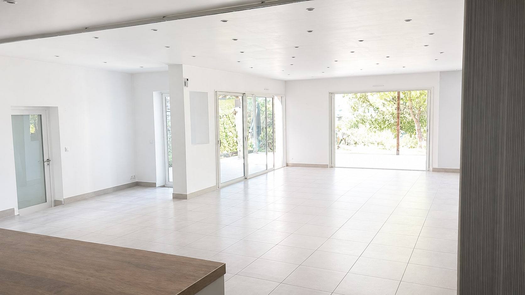Salle de réception ouverte sur le jardin par de grandes baies.