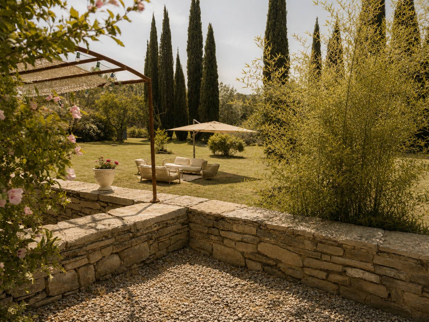 Jardin bordé de cyprès et de murets en pierre sèche.
