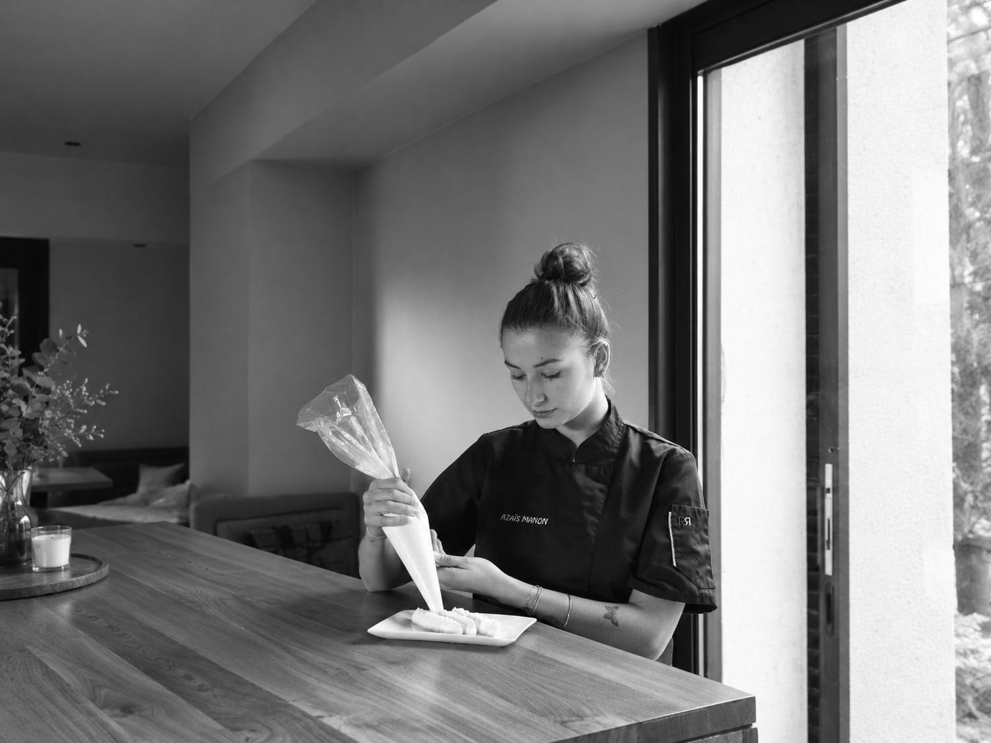 Manon, cheffe pâtissière de Pivoine et Sucre, dresse une pâtisserie à la poche.